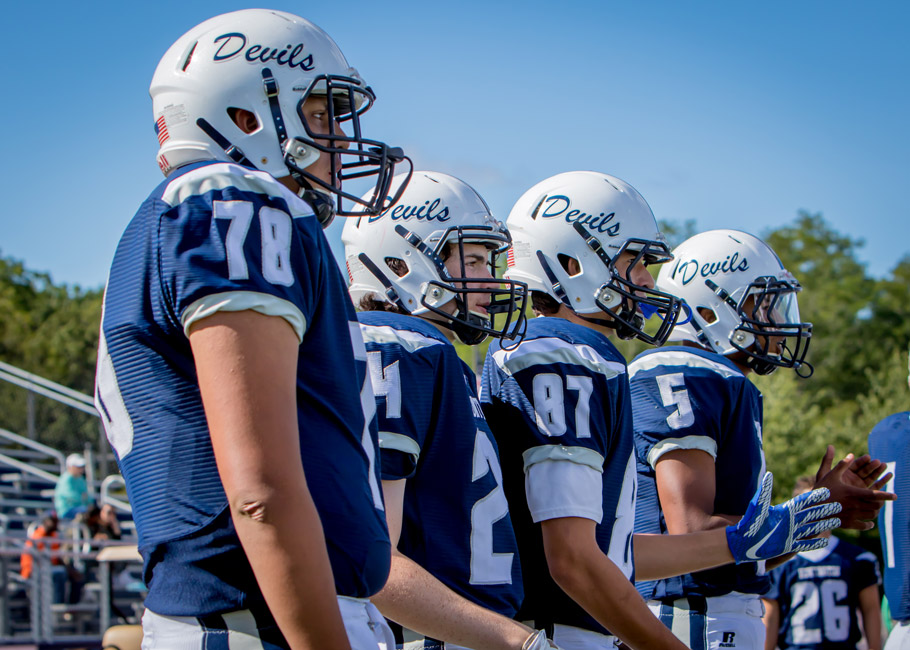 Blue Devil Football players stand on sideline