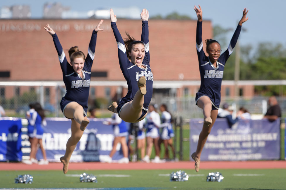 Sophia LaCentra (center) flies through the air with the Huntington Highsteppers. (Darin Reed photo.)