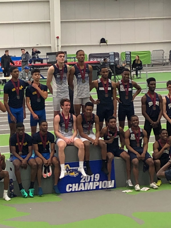 The Blue Devil boys' celebratedon the victory stand at the Ocean Breeze Track & Field Complex.