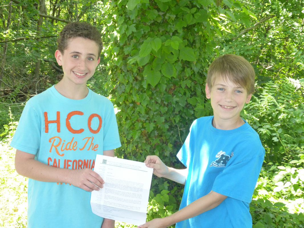 Woodhull sixth grader Noah Morris and fifth grader Andrew Knowles with a letter accepting them into the Institute for Creative Problem Solving.