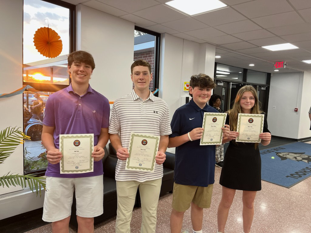  Newly inducted World Language Honor Societies members show off their induction certificates.  