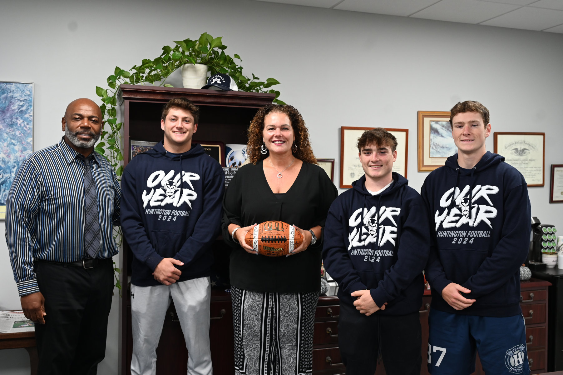  Superintendent Beth McCoy is flanked by Blue Devil players and head coach Ron Wilson.  