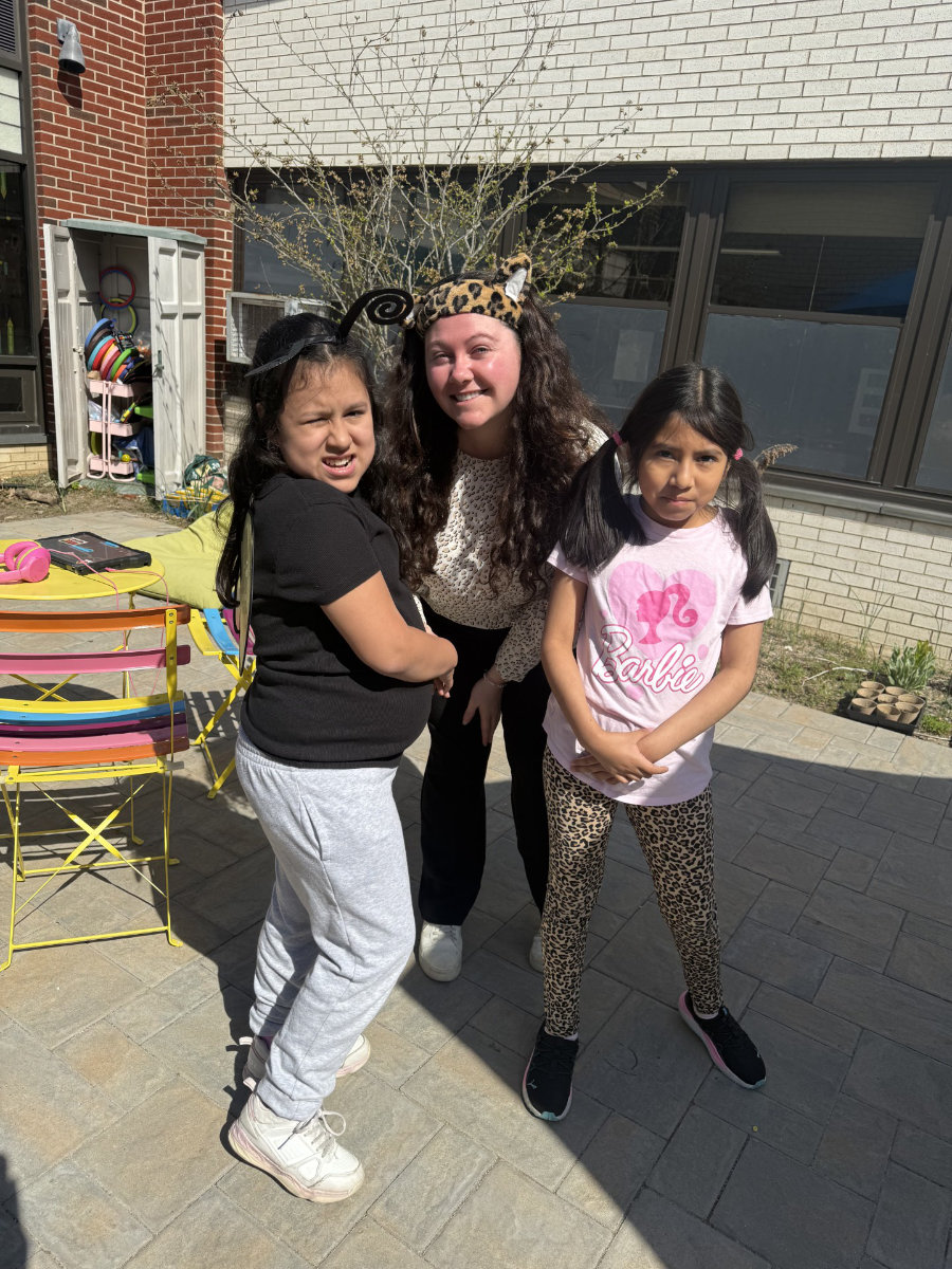  Mallory Travers flanked by students at Woodhull Intermediate School.  