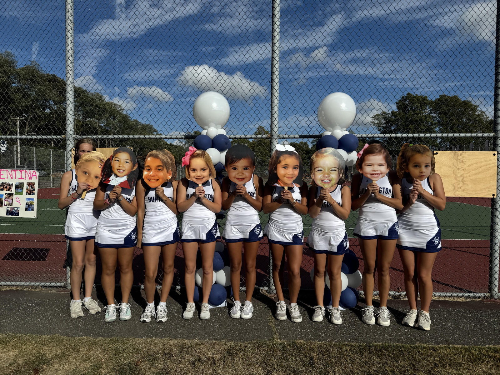 The nine seniors on the Huntington HIgh School girls' tennis team stand behind their baby photos.  
