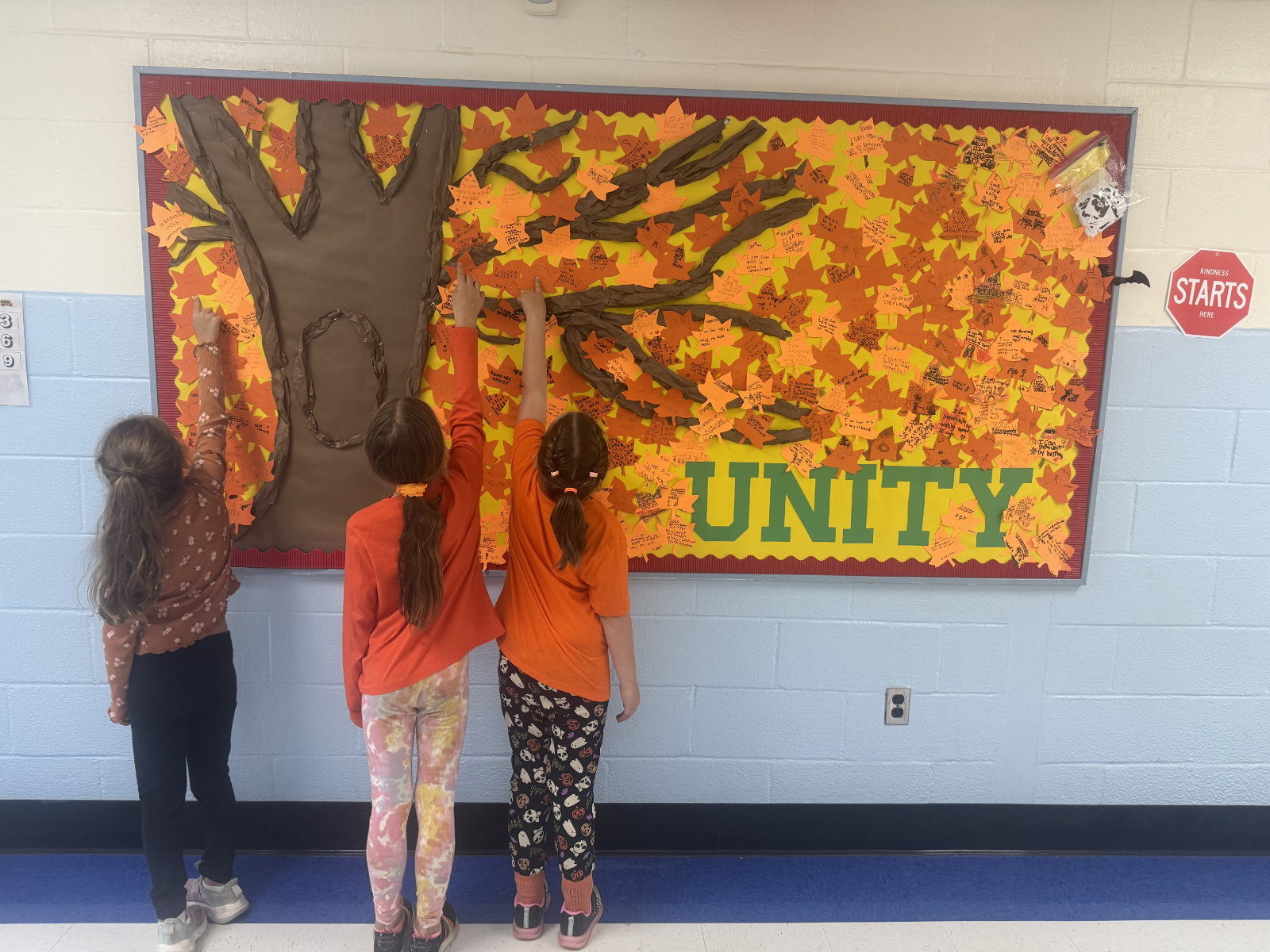 Students affixing leaves to the Unity Month tree.