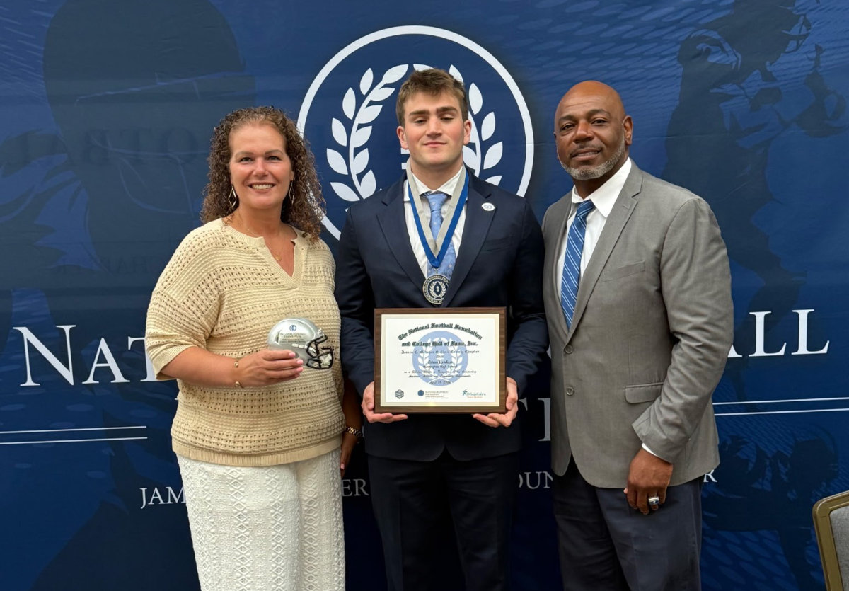 Ethan Lawless is flanked by Supt. Beth McCoy and Coach Ronald E. Wilson.  