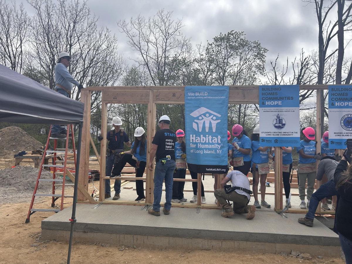 Huntington Habitat members raise the walls of the house they are sponsoring in Wyandanch.